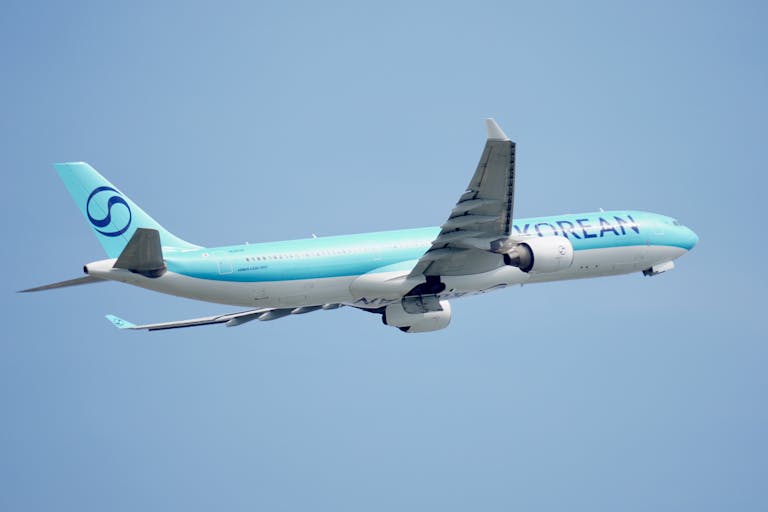 Commercial airplane flying high in the clear blue sky, showcasing travel and aviation themes.