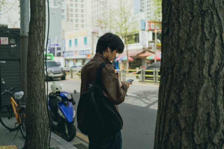 Person using Korea travel apps on smartphone while navigating Seoul street